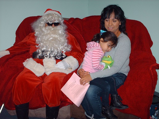 Santa posing with a Mother and child